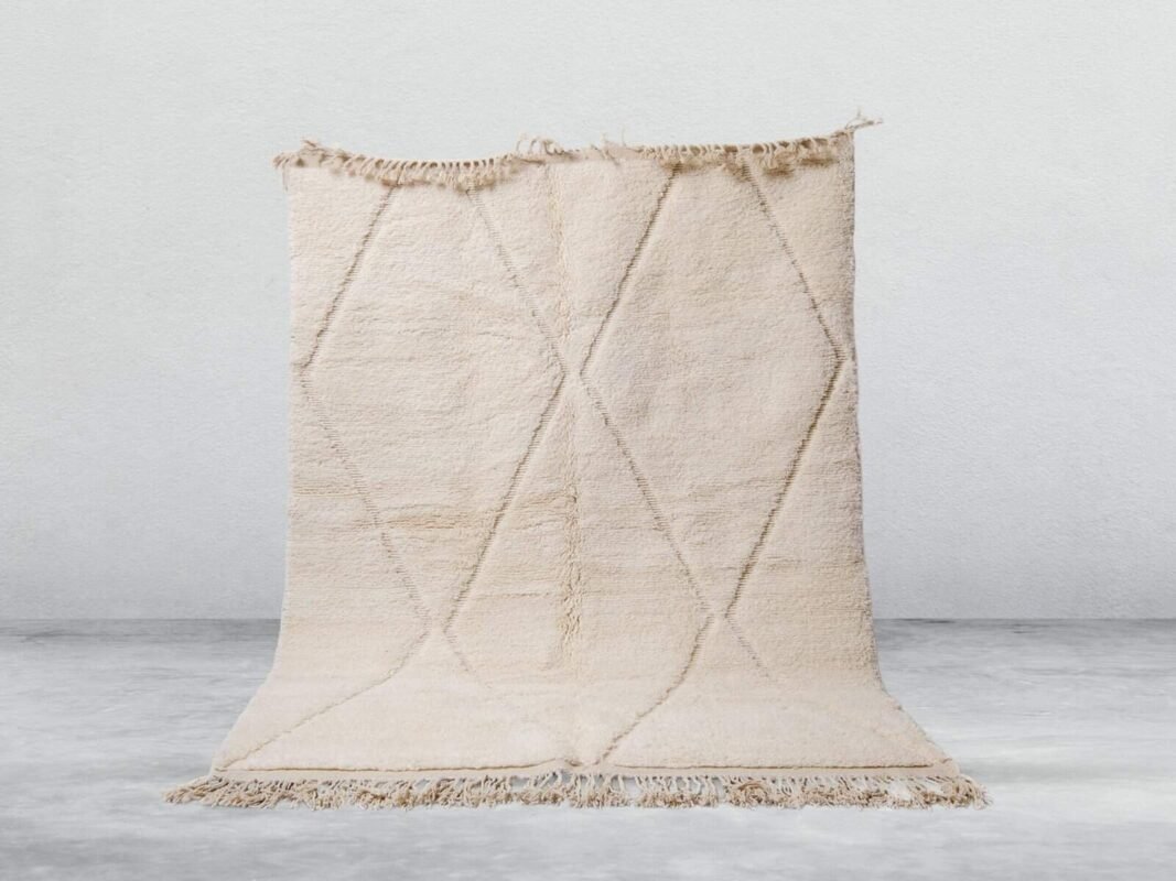 Handwoven Moroccan Beni Ourain rug with geometric patterns in neutral tones.